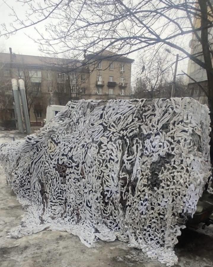 Finished camouflage net covering a vehicle